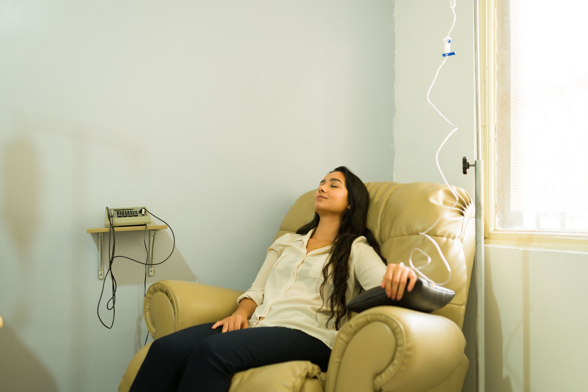 Relaxed woman healing getting a vitamin cocktail with an IV drip treatment